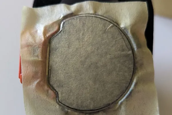 Tesa masking tape stuck to watch crystal with edges outlined in pencil.